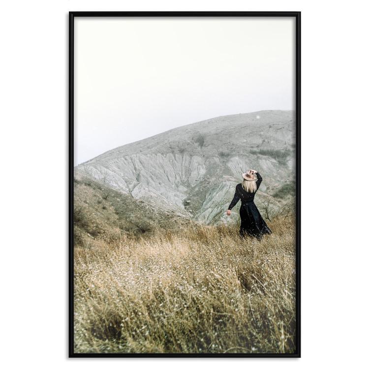 Poster Lost in Nature - landscape of a meadow with a woman against a mountain range