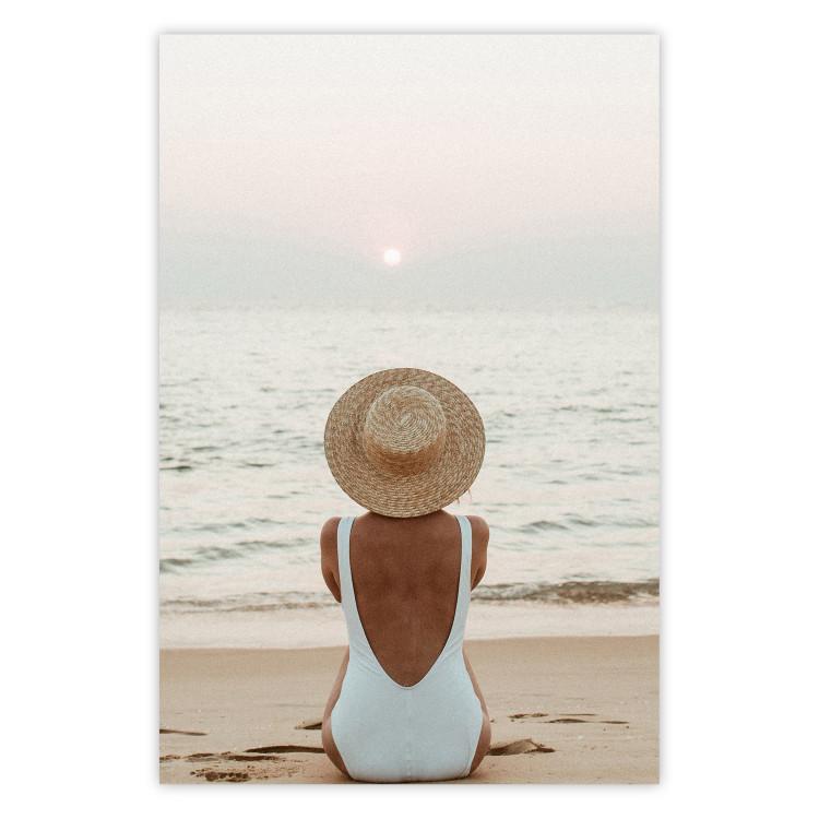Poster Beach Rest - woman sitting on the sand with sunset in the background