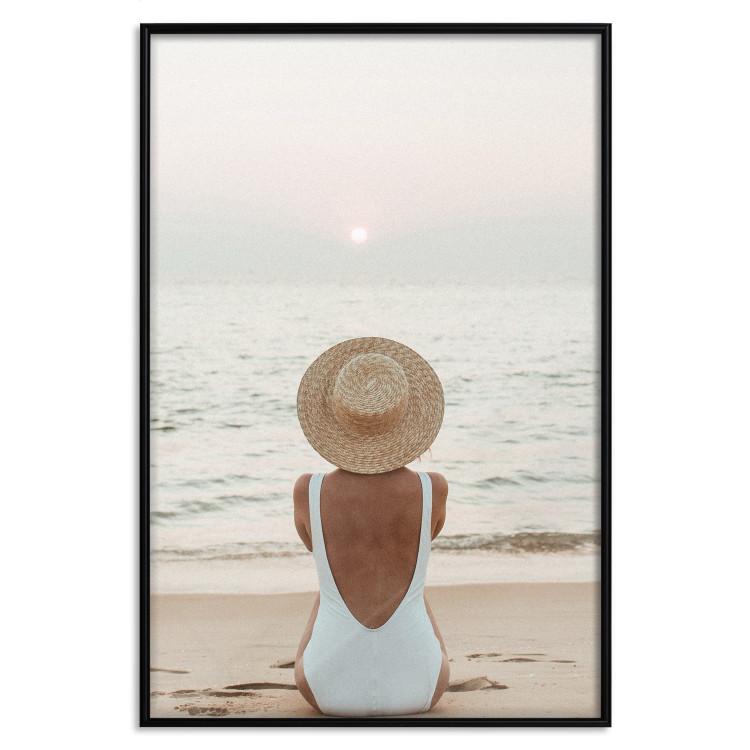 Poster Beach Rest - woman sitting on the sand with sunset in the background