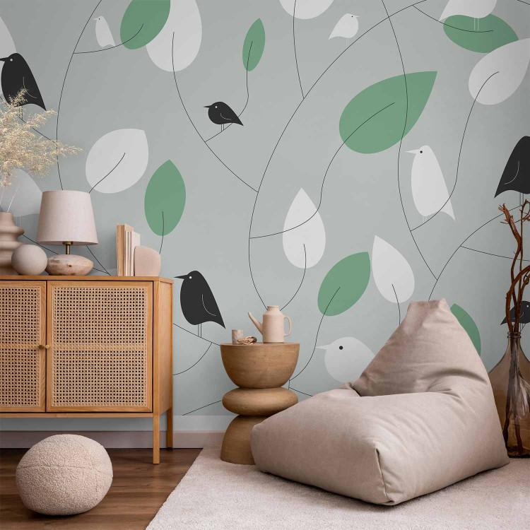Wall Mural Landscape - black and white birds on a grey background with green and white leaves