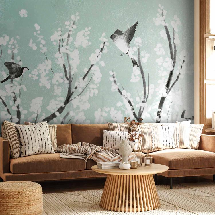 Wall Mural Trees with white flowers - birds in the branches in spring on a sea background