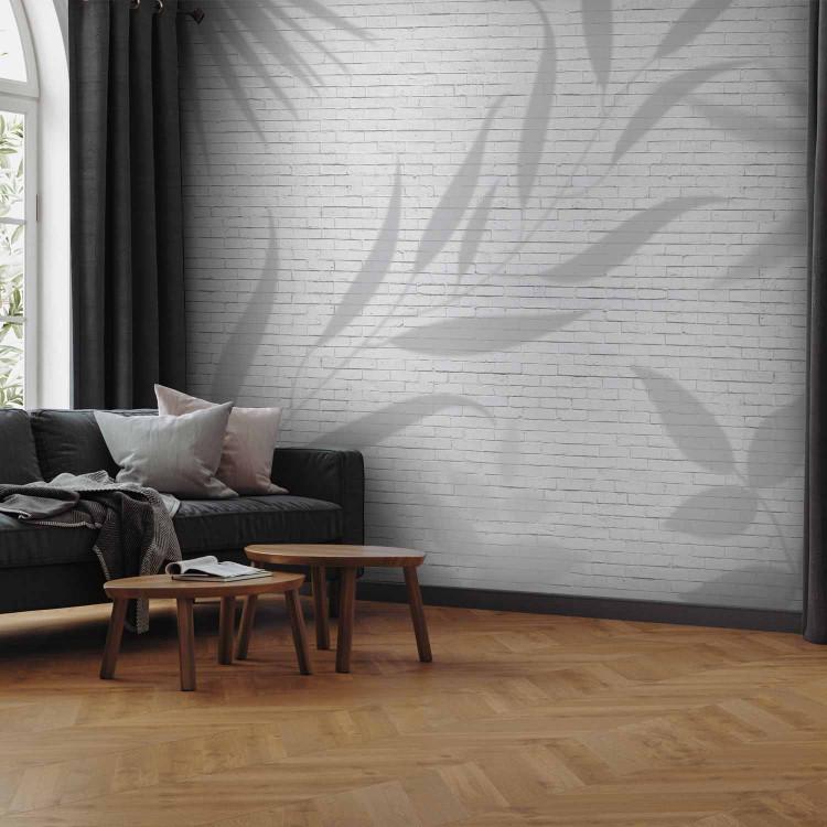 Wall Mural Leafy Illusion - A Shadow of Plant Leaves on a White Brick Wall Background