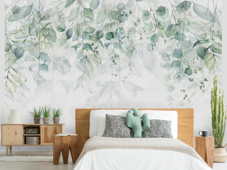 Wall Mural Cascade of Green - Delicate Twigs Full of Leaves on a Light Background