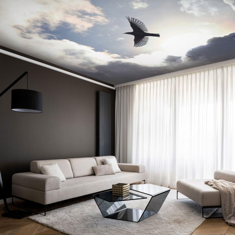 Wall Mural Flying Bird - Flight Against the Sky With Clouds and Sunshine