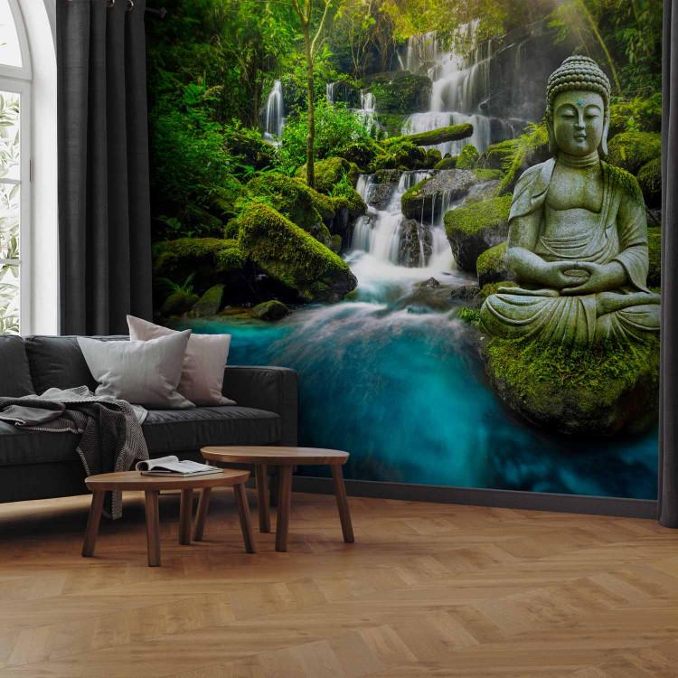 Wall Mural Orient - sculpture of Buddha on the background of a waterfall in highly saturated colours