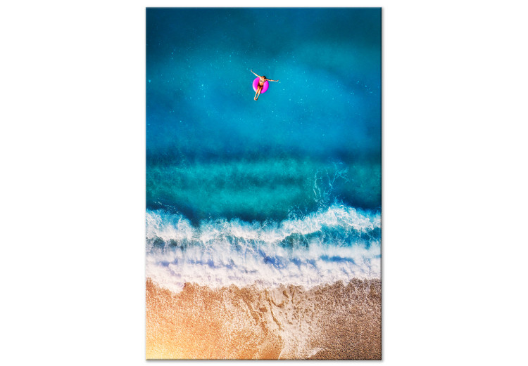 Canvas Print A moment of break - a figure sails to the sea on an inflatable wheel 116815