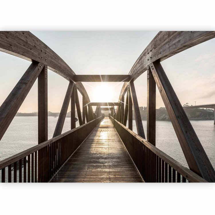 Wall Mural Bridge over the river - urban architectural landscape with a wooden bridge over the river with the sun in the background 74547 additionalImage 1