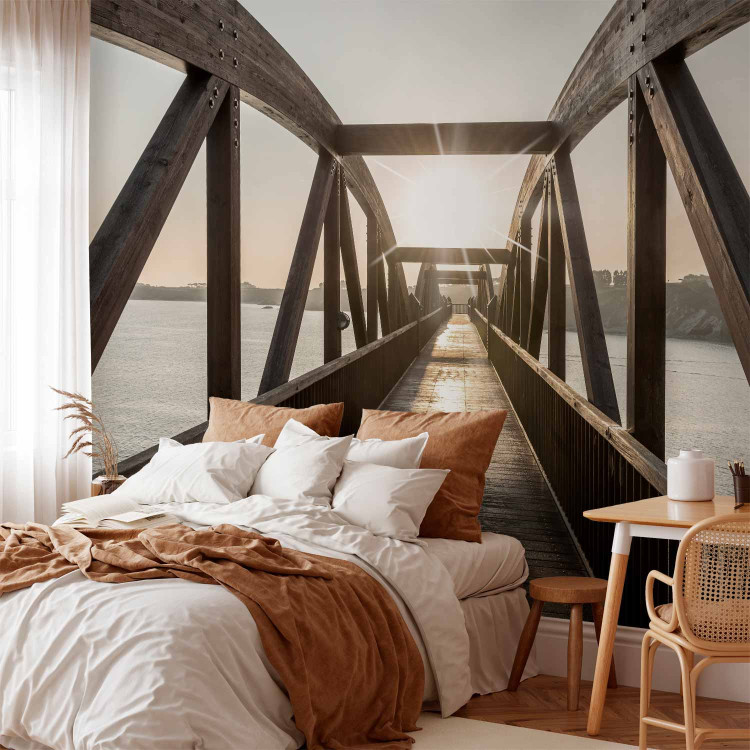 Wall Mural Bridge over the river - urban architectural landscape with a wooden bridge over the river with the sun in the background 74547 additionalImage 2